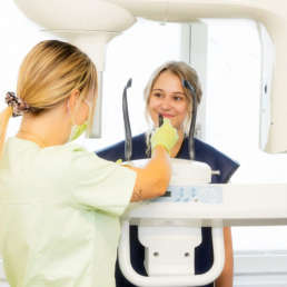 Frau bei Zahnarzt mit Sprechstundenhilfe bei Röntgenbehandlung