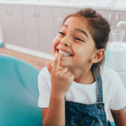 Kind zeigt Zähne beim Zahnarzt